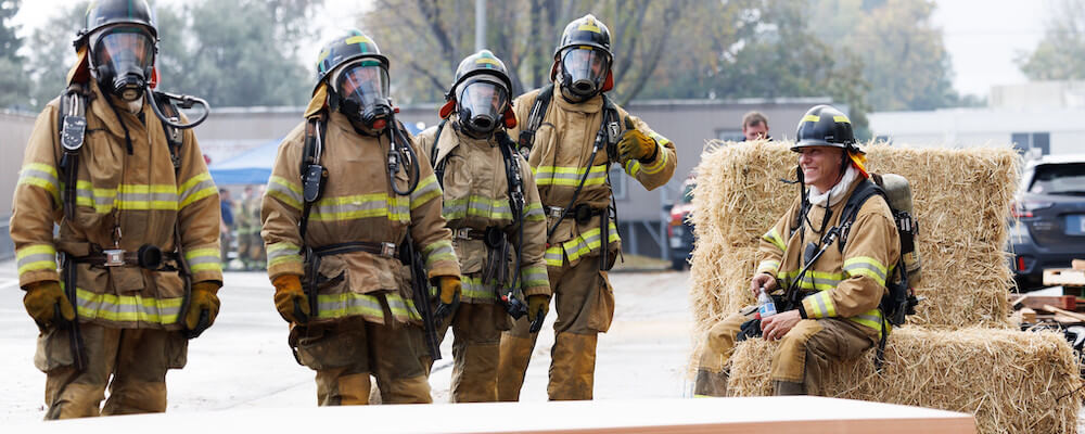 Firefighter Academy students work together in their uniforms.