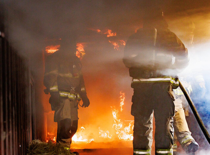 Firefighter Academy. Cadets battle a flame in their gear.