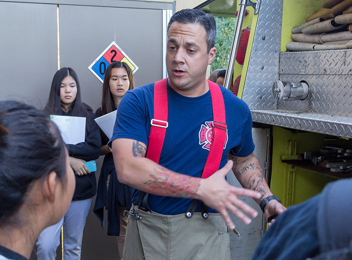 A firefighter instructs a group of cadets.