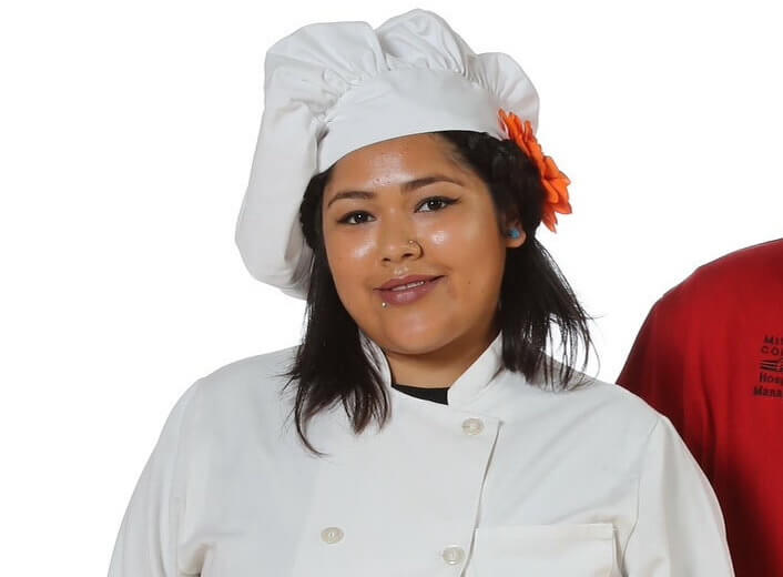 Female Hospitality Management student in her white uniform.