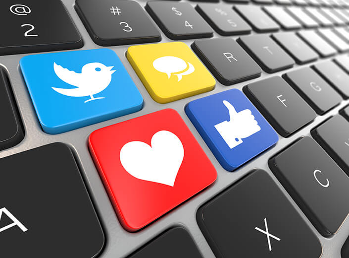 Social Media Marketing - icons for Twitter, Facebok, What's App are pictured on a laptop keyboard.