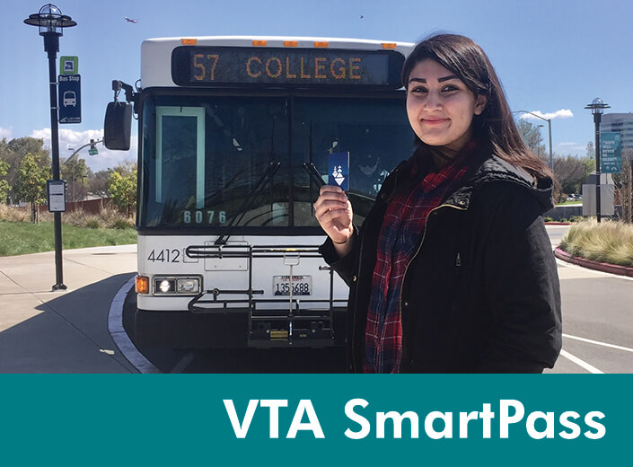 A young woman stands in front of a bus that says "57 College" on it's electronic display. She holds her VTA SmartPass card up. She has long dark hair, and wears a plaid button down shirt and black jacket. "VTA SmartPass" is written in white text across a teal strip on the bottom of the image.