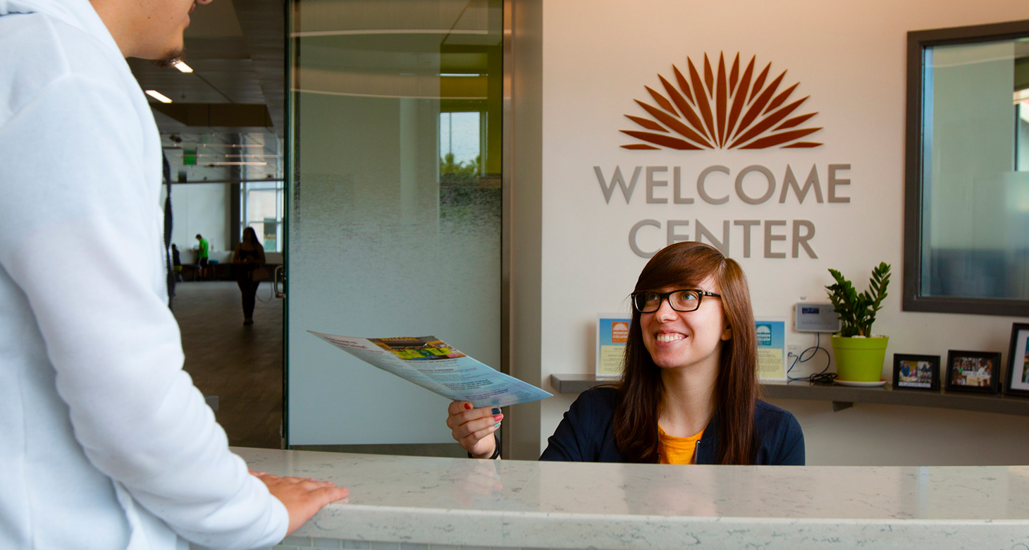 student at the welcome center desk