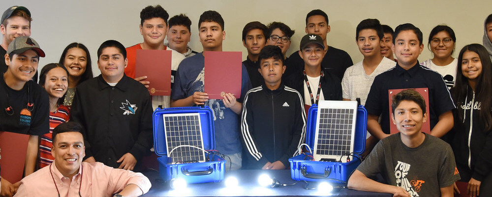 HSI Solar Suitcase event. A group of students poses with the finished solar suitcases.