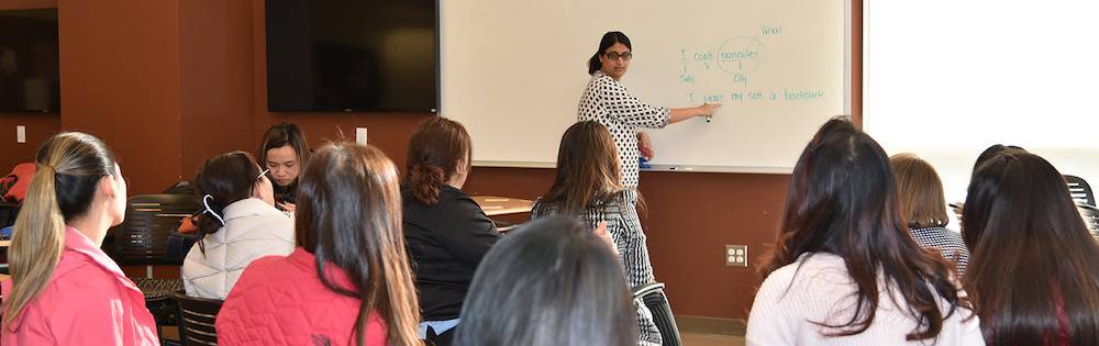 Woman leads tutoring session in classroom.