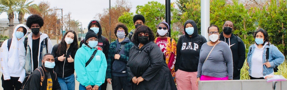 Group of Umoja students, some wearing masks, on Mission College campus.